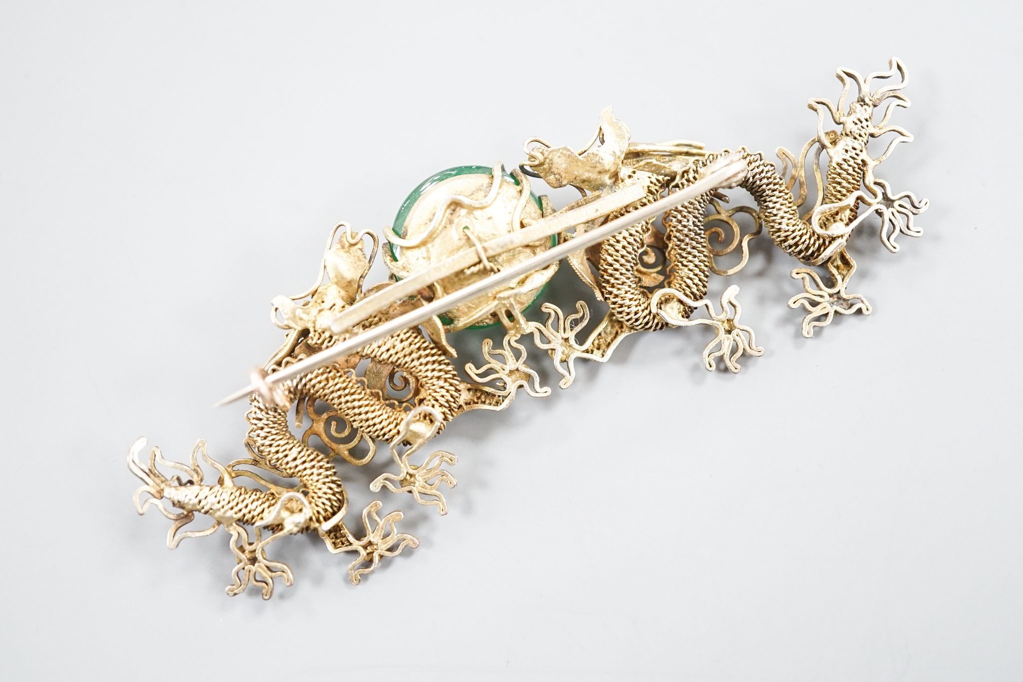 A Chinese gilt white metal and green cabochon set dragon brooch, 89mm.